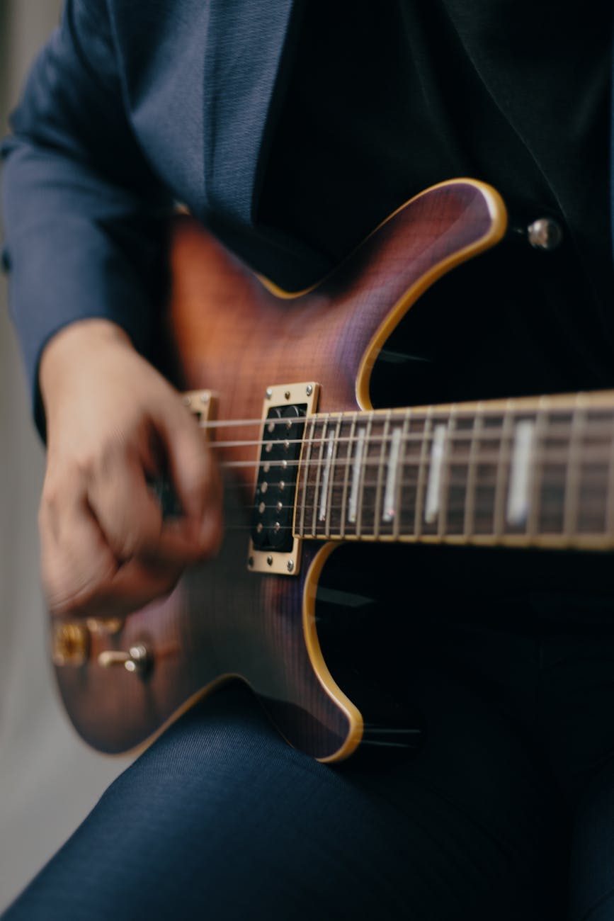 man hand playing guitar