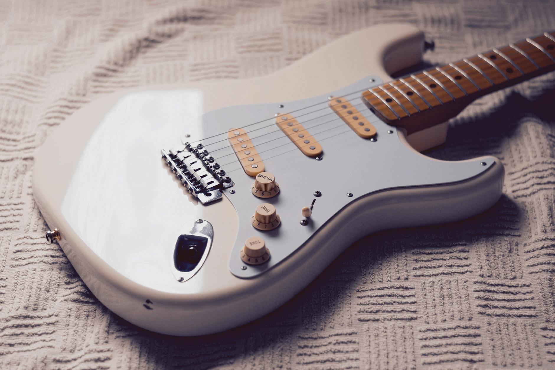 white stratocaster electric guitar on fabric