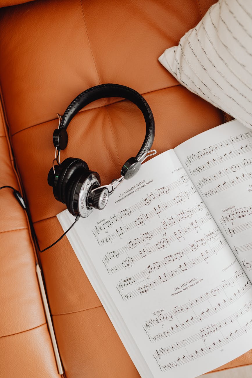 headphones and a music sheet on a couch