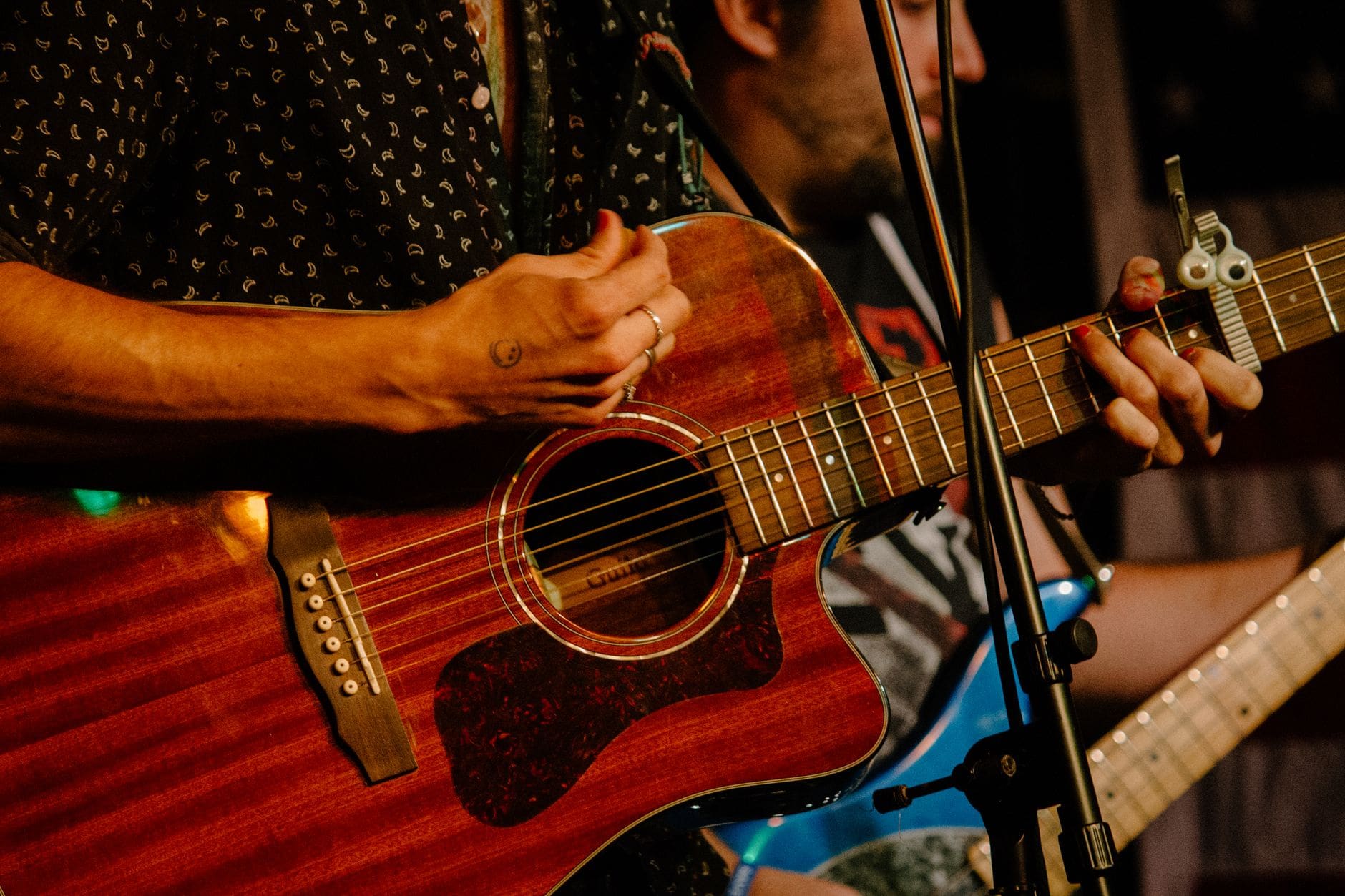 a person playing the acoustic guitar in a performance with a band
