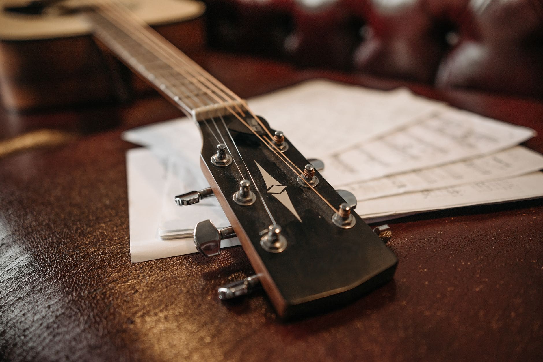 close up of an acoustic guitar lying on a wooden surface
